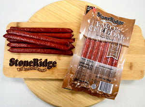 Bacon And Cheddar Meat Sticks (7 ounces, 7 sticks) on a cutting board.
